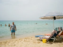 Djerba: průvodce — pláže, počasí a kdy jet Turista plave v mělkém moři na Djerbě