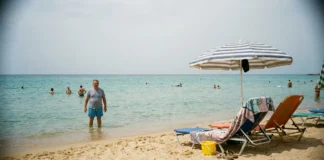 Djerba: průvodce — pláže, počasí a kdy jet Turista plave v mělkém moři na Djerbě