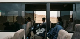 Výlety z Hurghady: ceny, Luxor, Káhira i pouštní safari Skupina turistů v minibusu během výletu pouští s výhledem na písčité kopce